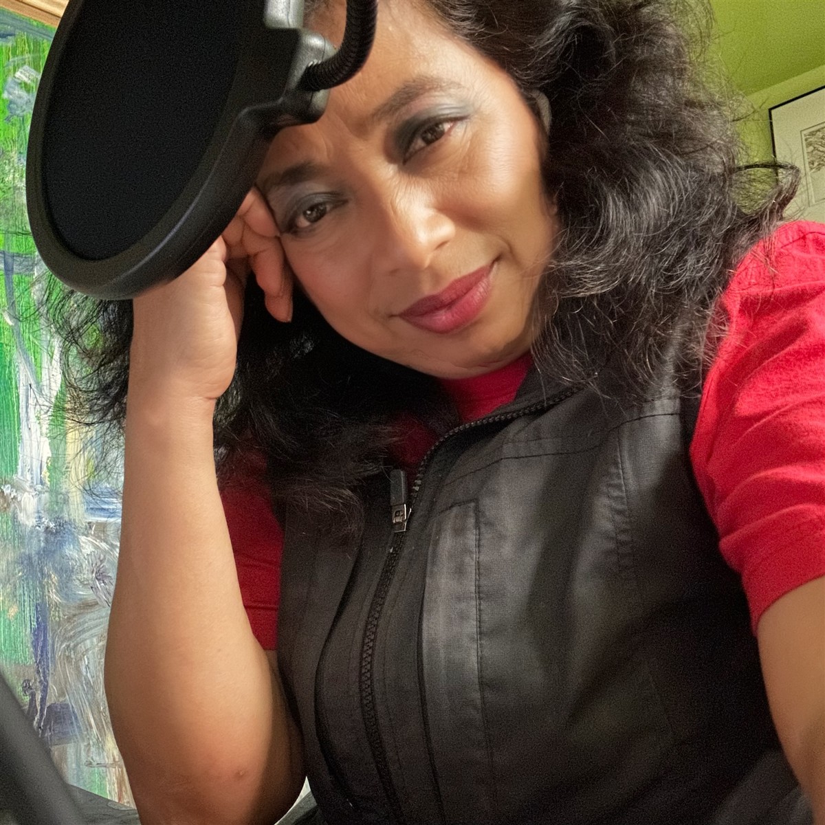 Michelle beside a microphone in her recording space